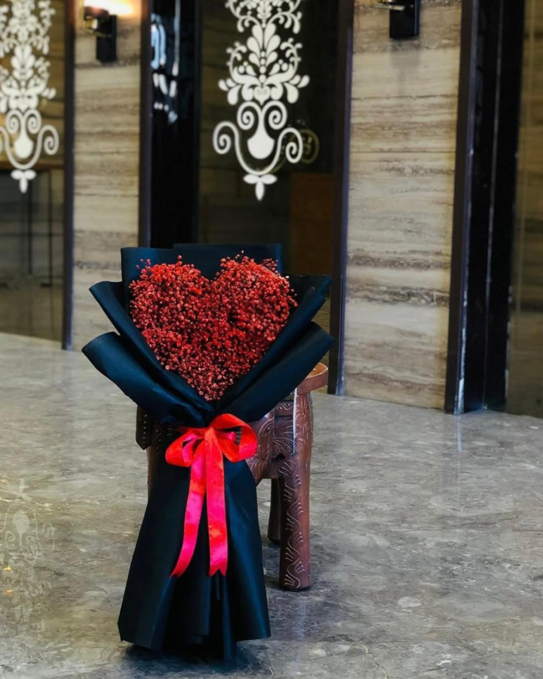 Red heart-shaped bouquet with black wrapping by Lavanta Florals